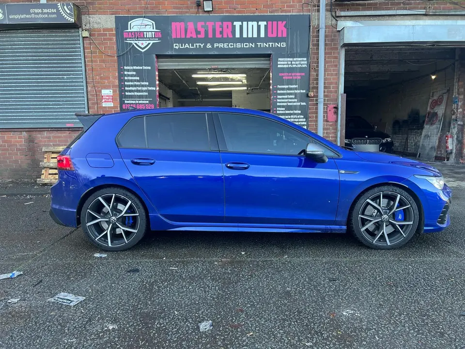 A blue VW Golf R photographed side-on outside our unit, the whole car in frame